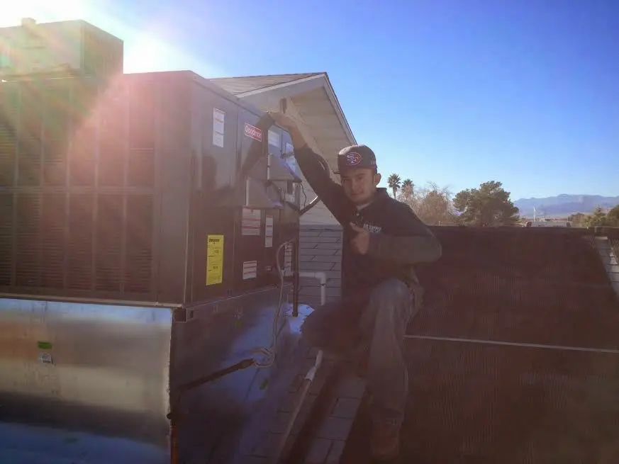 HVAC technician performing Boiler Repair on a rooftop unit in Mayfield